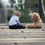 a baby boy playing with teddy bear